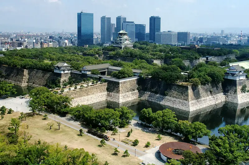 Castillo de Osaka rodeado por el foso y el parque, con la ciudad detrás