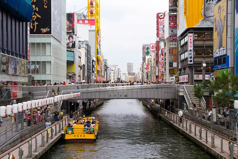 Canal de Dotonbori con barcos y carteles desde el puente Ebisubashi